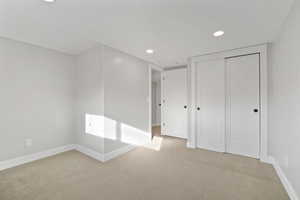 Bedroom with light carpet and a closet