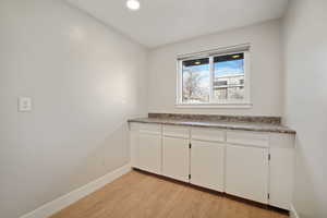 Laundry room with white cabinetry and counter workspace, and window with views of the backyard/Mt. Timp