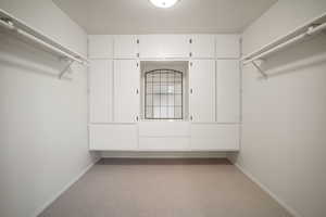 Walk in closet featuring built-in and mirror