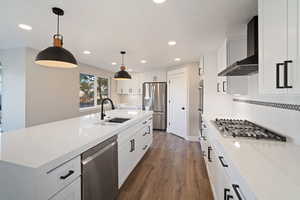 Kitchen with sink in the island, pendant lighting, and large corner pantry