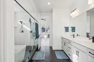 Bathroom with tile patterned floors, ceiling fan, vanity, and shower with separate bathtub