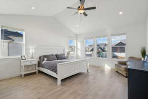 Bedroom with multiple windows, ceiling fan, lofted ceiling, and light wood-type flooring