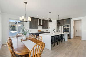 Dining area featuring light wood-type flooring, sink, and an inviting chandelier