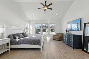 Bedroom with multiple windows, ceiling fan, high vaulted ceiling, and light hardwood / wood-style floors