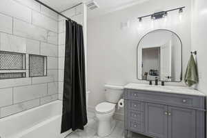 Full bathroom featuring toilet, vanity, and shower / tub combo with curtain