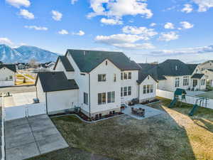 Back of property with a mountain view, a yard, central AC unit, a playground, and a patio