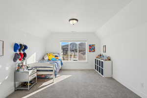 Carpeted bedroom featuring lofted ceiling