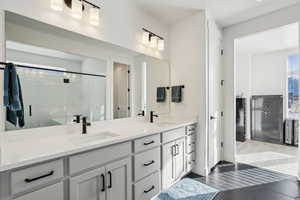 Bathroom featuring tile patterned floors, vanity, and walk in shower