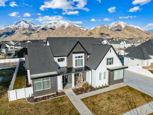 View of front of home with a mountain view and a front lawn