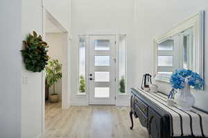 Entrance foyer featuring a high ceiling and light hardwood / wood-style floors