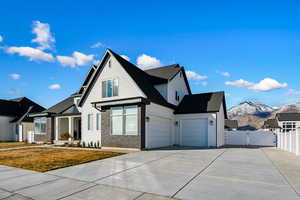 View of front of property featuring a mountain view, a garage, and a front yard