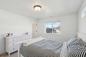 Bedroom with light colored carpet and multiple windows