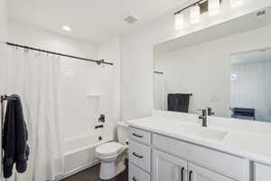 Full bathroom with tile patterned flooring, vanity, toilet, and shower / tub combo with curtain