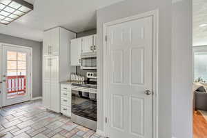 Kitchen featuring white cabinets and appliances with stainless steel finishes