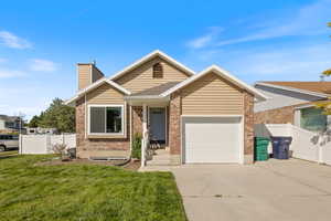 View of front of home featuring a front lawn and a garage