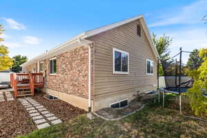 View of side of home featuring a deck and a trampoline