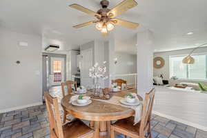 Dining room with ceiling fan and a healthy amount of sunlight