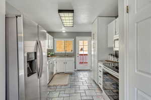 Kitchen with white cabinets, appliances with stainless steel finishes, and sink