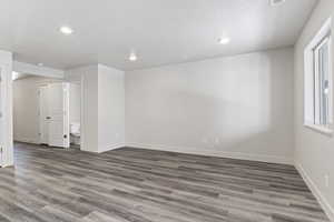 Spare room featuring a textured ceiling and dark wood-type flooring