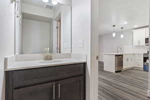 Bathroom featuring hardwood / wood-style flooring, vanity, a textured ceiling, and tasteful backsplash