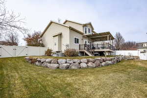 Back of house with a yard and a wooden deck