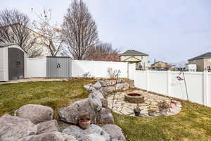 View of yard with a shed and an outdoor fire pit