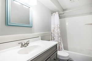 Full bathroom with vanity, toilet, and shower / bathtub combination with curtain