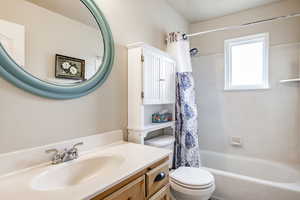 Full bathroom featuring vanity, toilet, and shower / bath combo with shower curtain