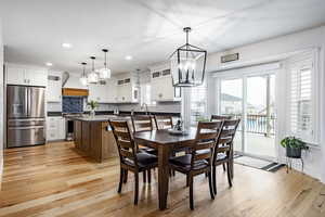 Dining room featuring sink, plenty of natural light, light hardwood / wood-style floors, and a notable chandelier