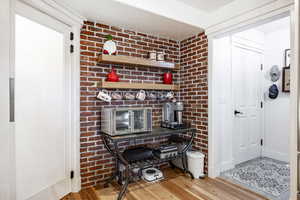 Foyer with hardwood / wood-style flooring and brick wall