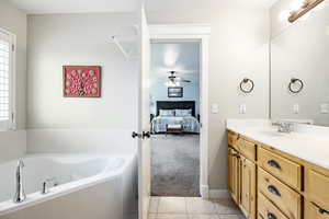 Bathroom with a washtub, vanity, tile patterned floors, and a healthy amount of sunlight