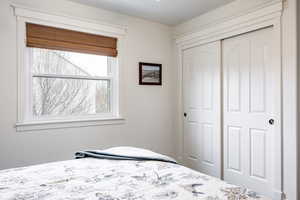 Bedroom featuring multiple windows and a closet