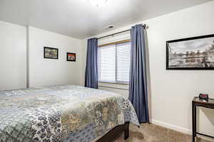 Bedroom with carpet and a textured ceiling