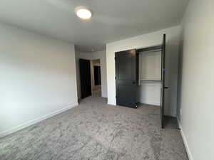 Unfurnished bedroom with a closet, carpet, and a textured ceiling