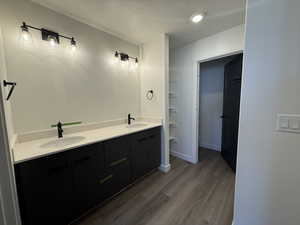 Bathroom featuring hardwood / wood-style floors, vanity, and a textured ceiling