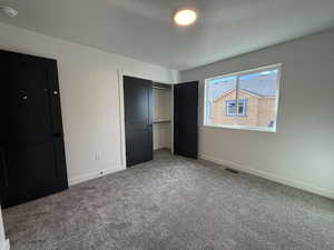 Unfurnished bedroom with carpet flooring and a closet