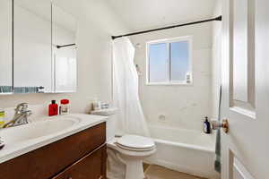 Full bathroom featuring shower / bathtub combination with curtain, vanity, and toilet