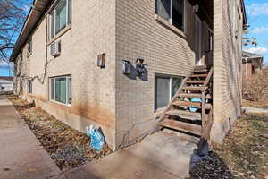 View of side of home with a wall mounted AC