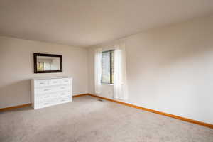 Unfurnished bedroom with light colored carpet