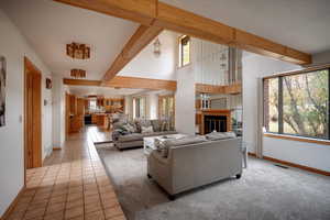 Living room featuring beam ceiling and light tile patterned floors