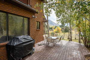 Wooden deck featuring a mountain view and area for grilling