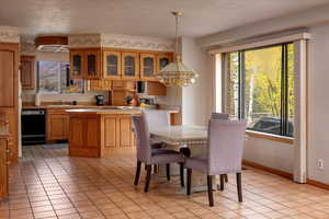 Tiled dining area featuring sink, a textured ceiling, and a chandelier