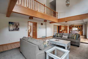 Living room with light tile patterned flooring and a high ceiling