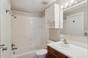 Full bathroom with vanity,  shower combination, and toilet