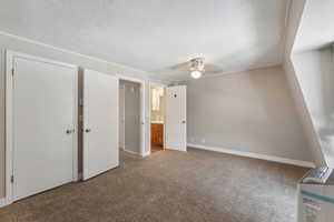 Unfurnished bedroom with carpet flooring, ensuite bathroom, and ceiling fan