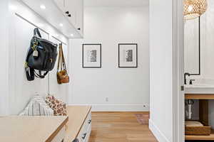 Mudroom with light hardwood / wood-style floors and sink