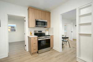 ADU Kitchen featuring tasteful backsplash, light brown cabinets, LVP flooring, and Stainless Steel appliances