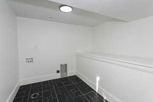 Laundry room featuring washer hookup and electric dryer hookup, all new tile.