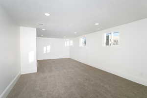 Basement with carpet and a textured ceiling