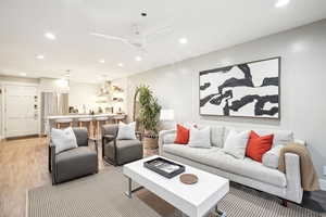 Living room with ceiling fan and light hardwood / wood-style flooring